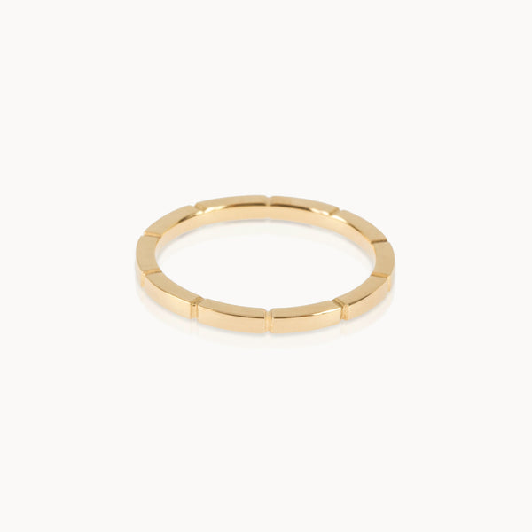 Fairmined gold band featuring precise notched pattern, minimalist sustainable ring design.