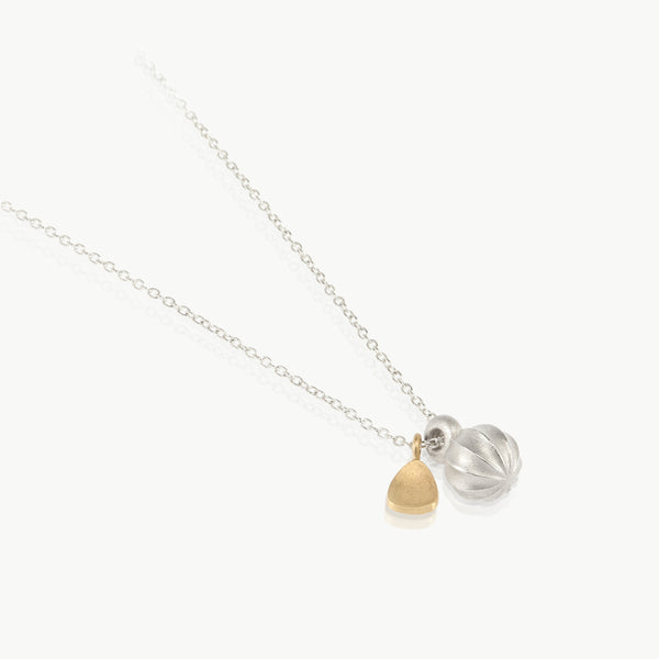 Fine jewellery handmade in Cape Town – A silver chain with a sterling silver seed charm and an ethically mined 9K gold leaf charm.