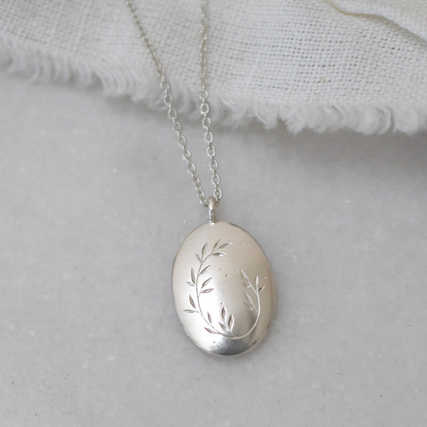 Handmade silver pendant with detailed leaf engraving, minimal modern jewellery piece for everyday wear.