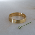 Flat profiled environmentally friendly recycled gold wedding band with single ethical diamond
