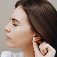 Woman wearing ethical gold earrings. These minimalist 9mm Hemisphere Studs are handmade in Cape Town in recycled gold from e-waste.