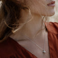 Woman wearing eco-friendly silver necklace. This sustainable Pod Pendant with Leaf is handmade in Cape Town in recycled silver from e-waste.