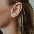 Woman wearing sustainable silver earrings. These artisan crafted Twist Hoops are handmade in Cape Town in recycled silver from e-waste.