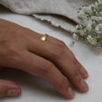 Knife Edge eco-friendly recycled gold wedding band on woman's hand