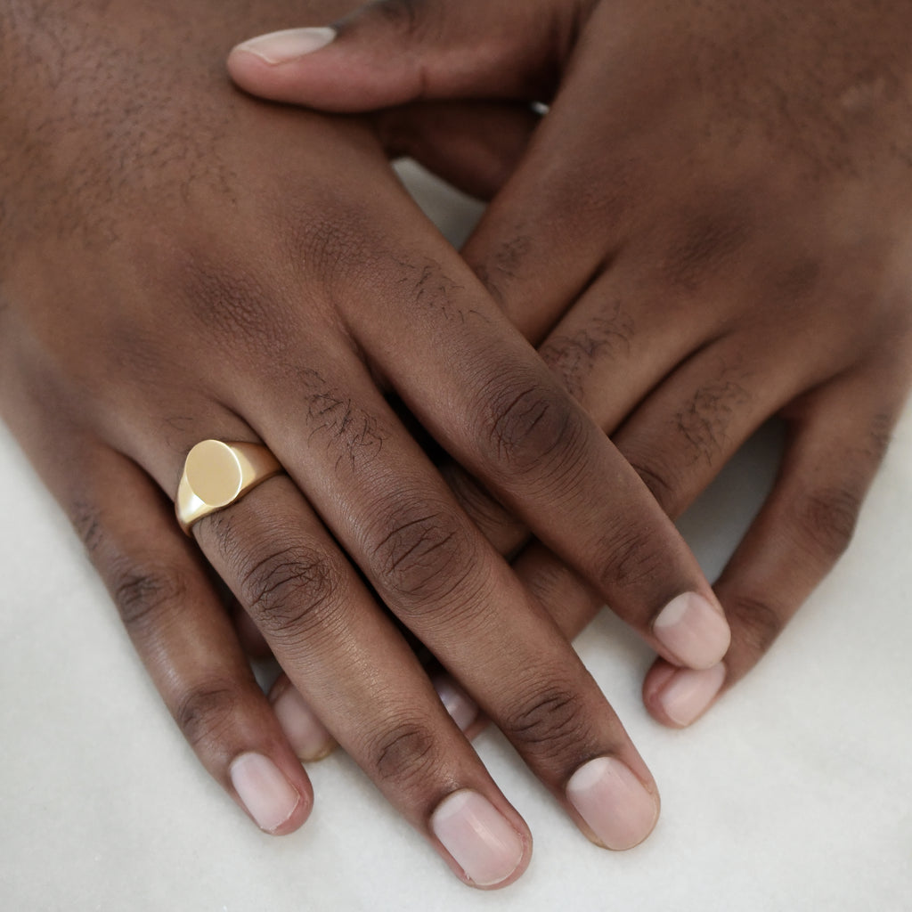 Eco-friendly gold signet ring on man's hand, bold and sustainable statement jewellery. Engravable.