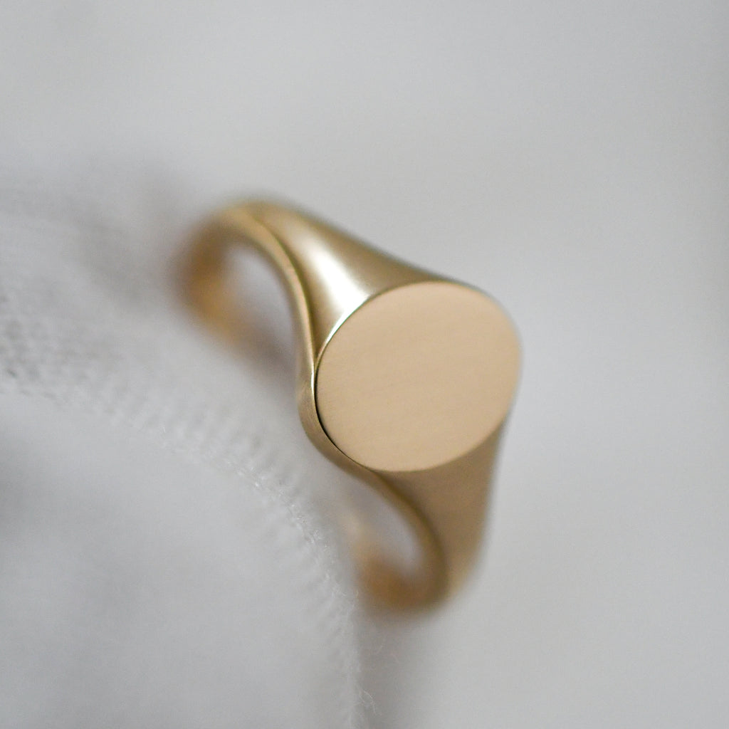 Sustainable oval dainty signet ring in yellow gold, eco-conscious fine jewelry