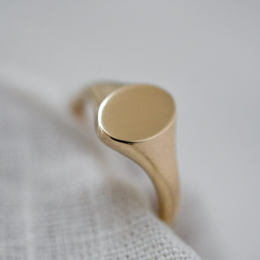 Eco-conscious dainty 9K yellow gold signet ring, timeless and sustainably crafted.