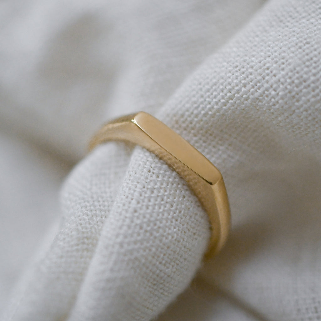Eco-friendly dainty gold signet ring, ethically crafted with a slim profile.