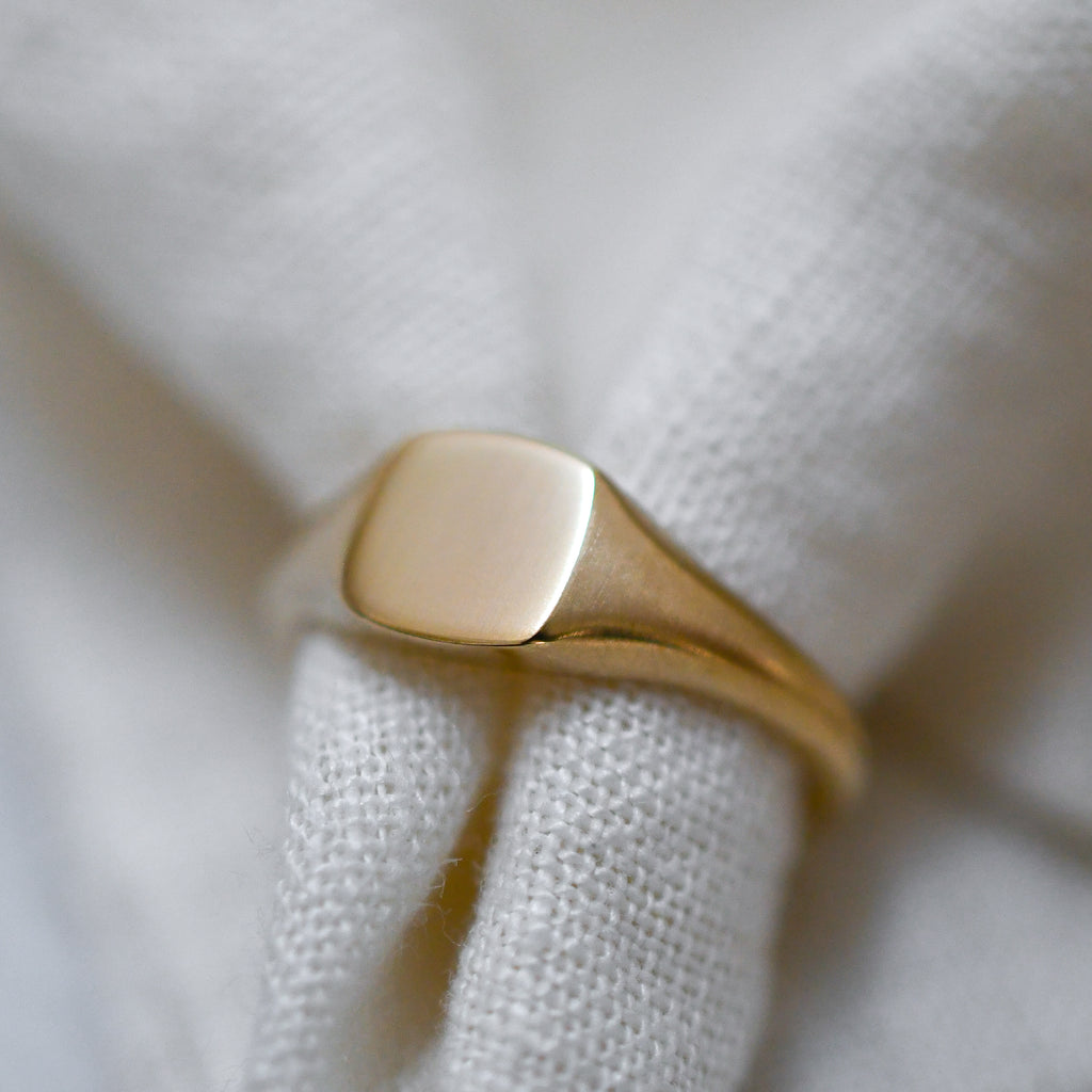Minimalist ethical 9K gold signet with a square face.