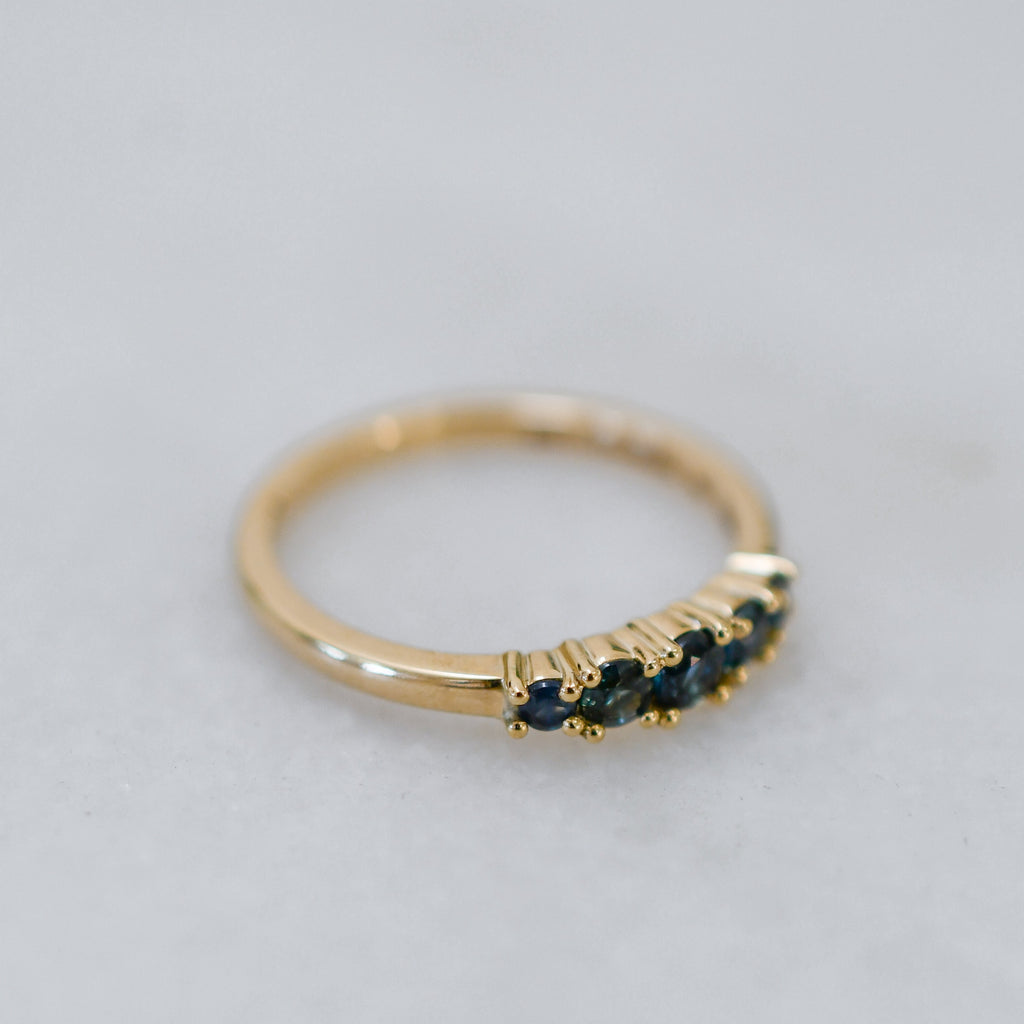 Handmade 9ct gold ring with claw-set blue sapphires in varying shades for a minimalist engagement ring