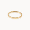 Fairmined gold band featuring precise notched pattern, minimalist sustainable ring design.