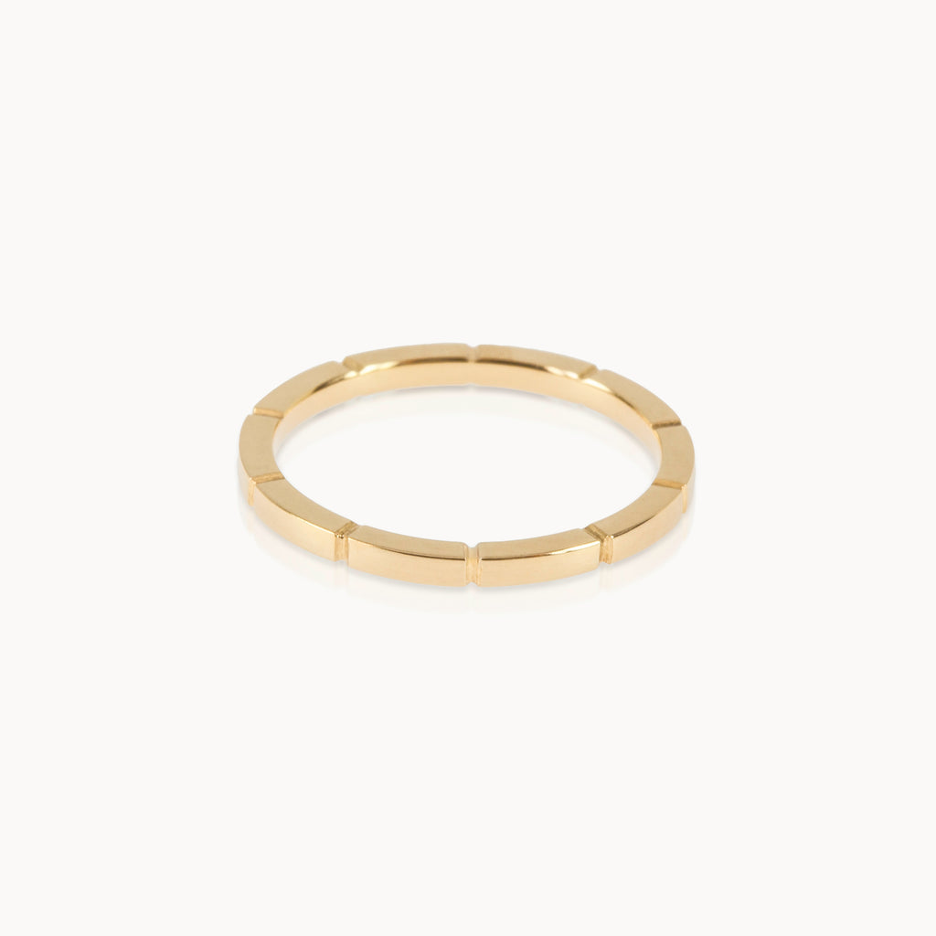 Fairmined gold band featuring precise notched pattern, minimalist sustainable ring design.