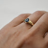 Ethically sourced blue sapphire ring worn on a woman's hand, bezel-set in 9ct gold