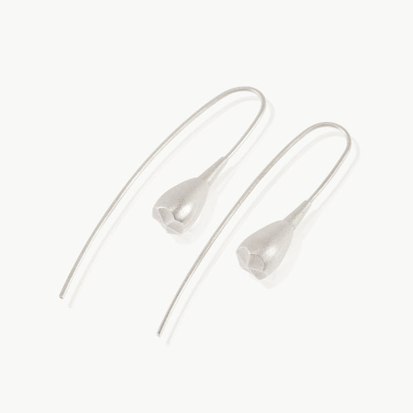 A minimalist seed pod hanging at the end of a wire drop earring is botanically inspired and expertly crafted in sterling silver in South Africa.