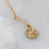 Fairmined gold necklace with a circular pendant featuring a lab-grown diamond on a light gray background.