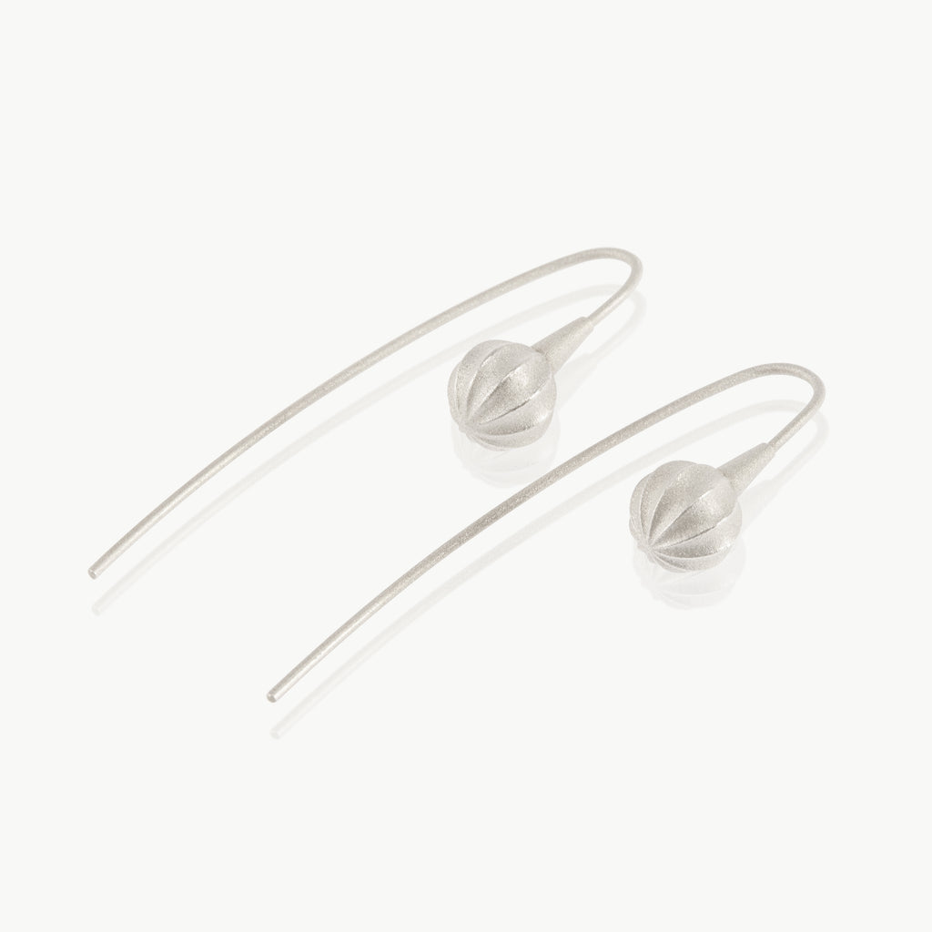 A minimalist seed at the end of a wire drop earring expertly handmade in sterling silver in our well-established fine jewellery design studio in Cape Town.