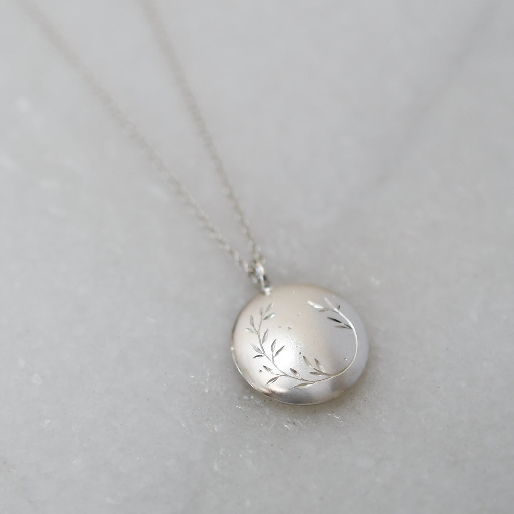 Round sterling silver pendant handcrafted in ethically sourced, eco-friendly silver with a hand-engraved wreath design.
