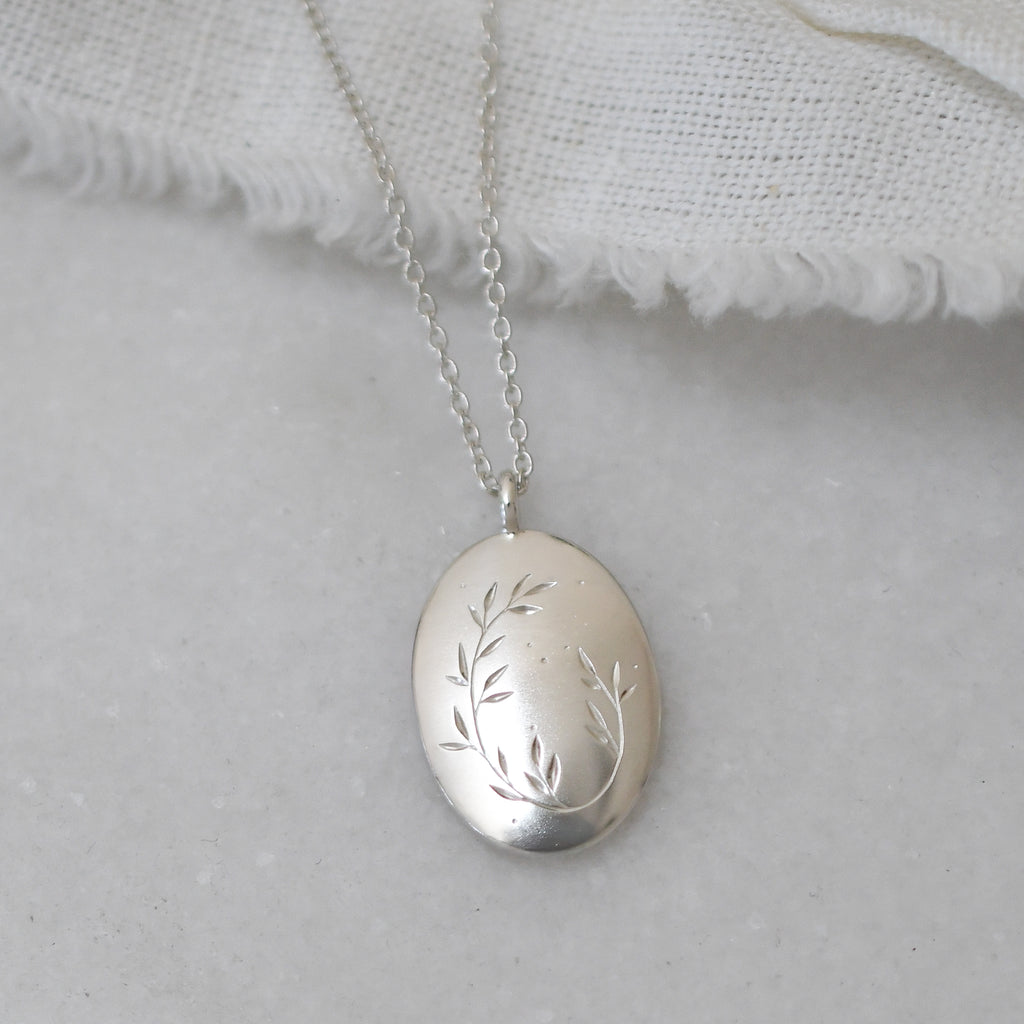 Handmade silver pendant with detailed leaf engraving, minimal modern jewellery piece for everyday wear.