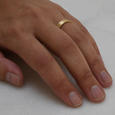 Flat profiled eco-friendly recycled gold wedding band on woman's hand