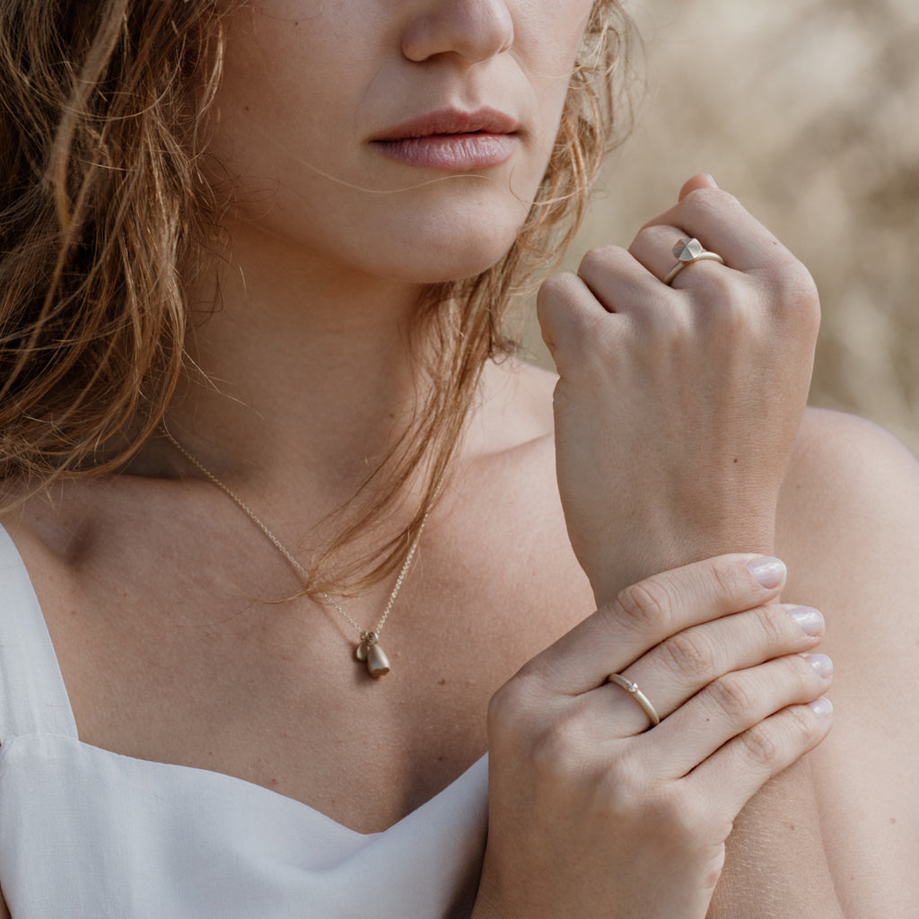 Woman wearing an ethical gold ring. This minimalist Growth Ring is handmade in Cape Town in recycled gold from e-waste.