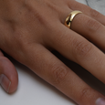 Hammered, eco-friendly recycled gold wedding band on woman's hand