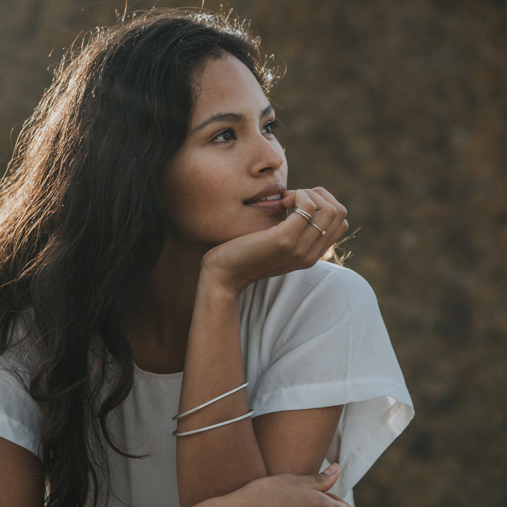 Woman wearing ethical silver bracelet. This minimalist Simple Oval Bangle is handmade in Cape Town in recycled silver from e-waste.