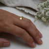 Knife Edge eco-friendly gold wedding band on woman's hand.