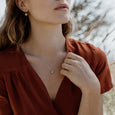 Woman wearing sustainable silver and gold necklace. This artisan crafted Seed Pendant with Leaf is handmade in Cape Town in recycled silver and gold from e-waste.