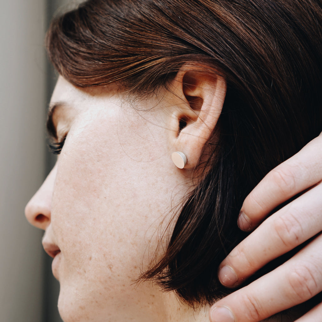 Woman wearing eco-friendly gold earrings. These sustainable 9mm Hemisphere Studs are handmade in Cape Town in recycled gold from e-waste.