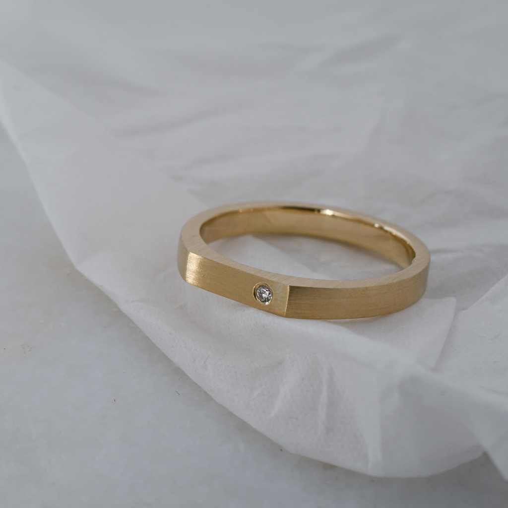 Signet shaped eco-friendly gold wedding band with single ethically sourced lab-grown diamond.
