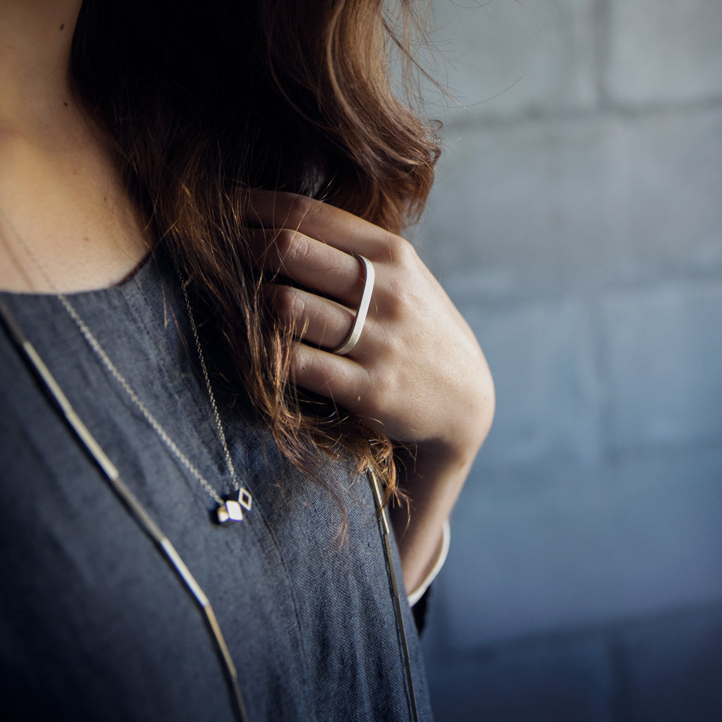 Woman wearing an ethical silver ring. This minimalist Double Finger Ring is handmade in Cape Town in recycled silver from e-waste.