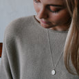 Woman wearing sustainable silver pendant. This ethical Ocean Soul Pendant is handmade in Cape Town in recycled silver from e-waste.