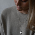 Woman wearing sustainable silver necklace. This ethical Wanderlust Pendant is handmade in Cape Town in recycled silver from e-waste.